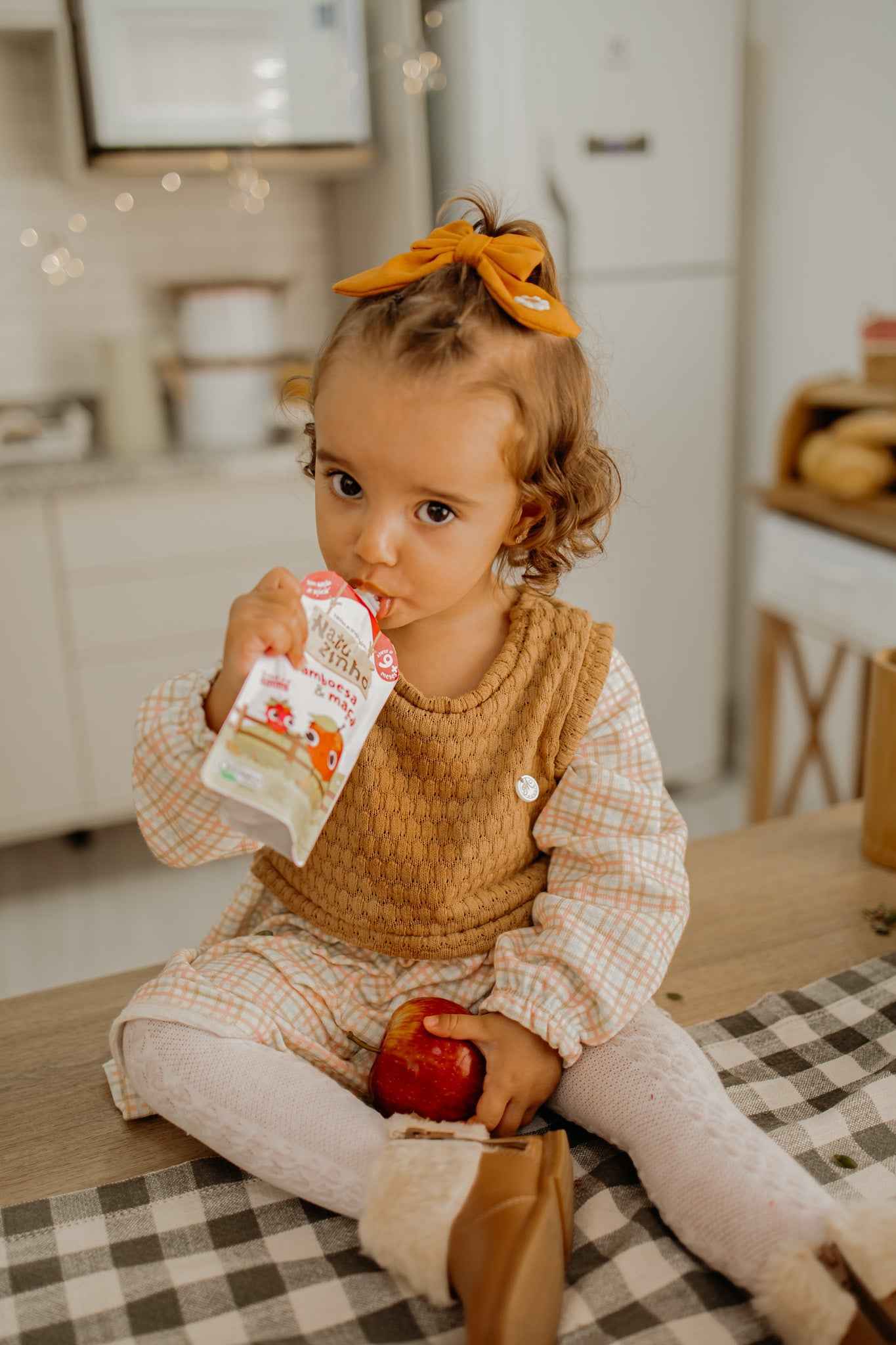 Papinha Organica Natural de Fruta sabor Framboesa e Maça Natuzinho - bebe sentado em cima do balcao, comendo natuzinho