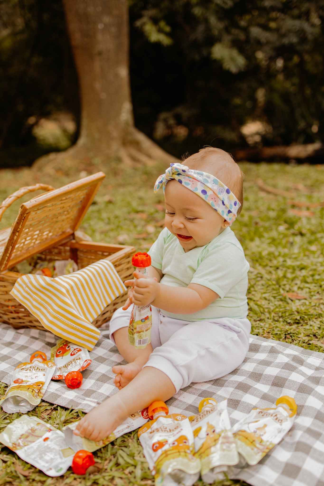 Papinha Organica Natural de Fruta sabor Banana Natuzinho - Bebe sentada no parque comendo natuzinho