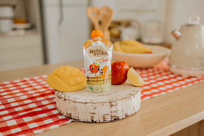 Manga e MaçãPapinha Organica Natural de Fruta sabor Manga e maça Natuzinho - em cima do balcao, com pedaços de fruta ao lado - manga e maça